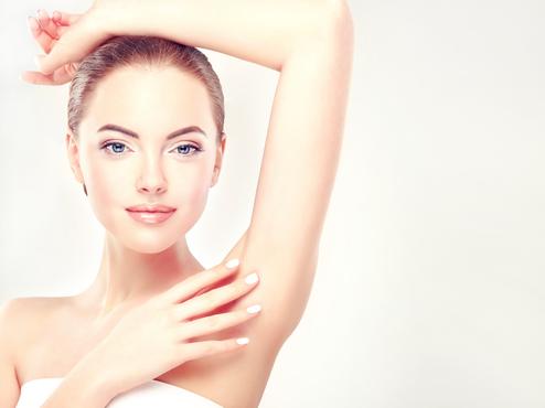 Frau mit erhobenem Arm und glatter Haut unter Achsel